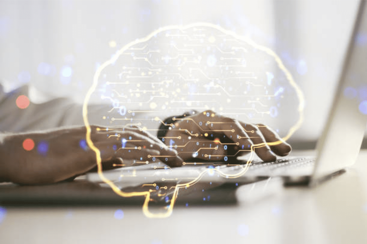 Person typing on laptop with brain image, symbolizing technology and intellect